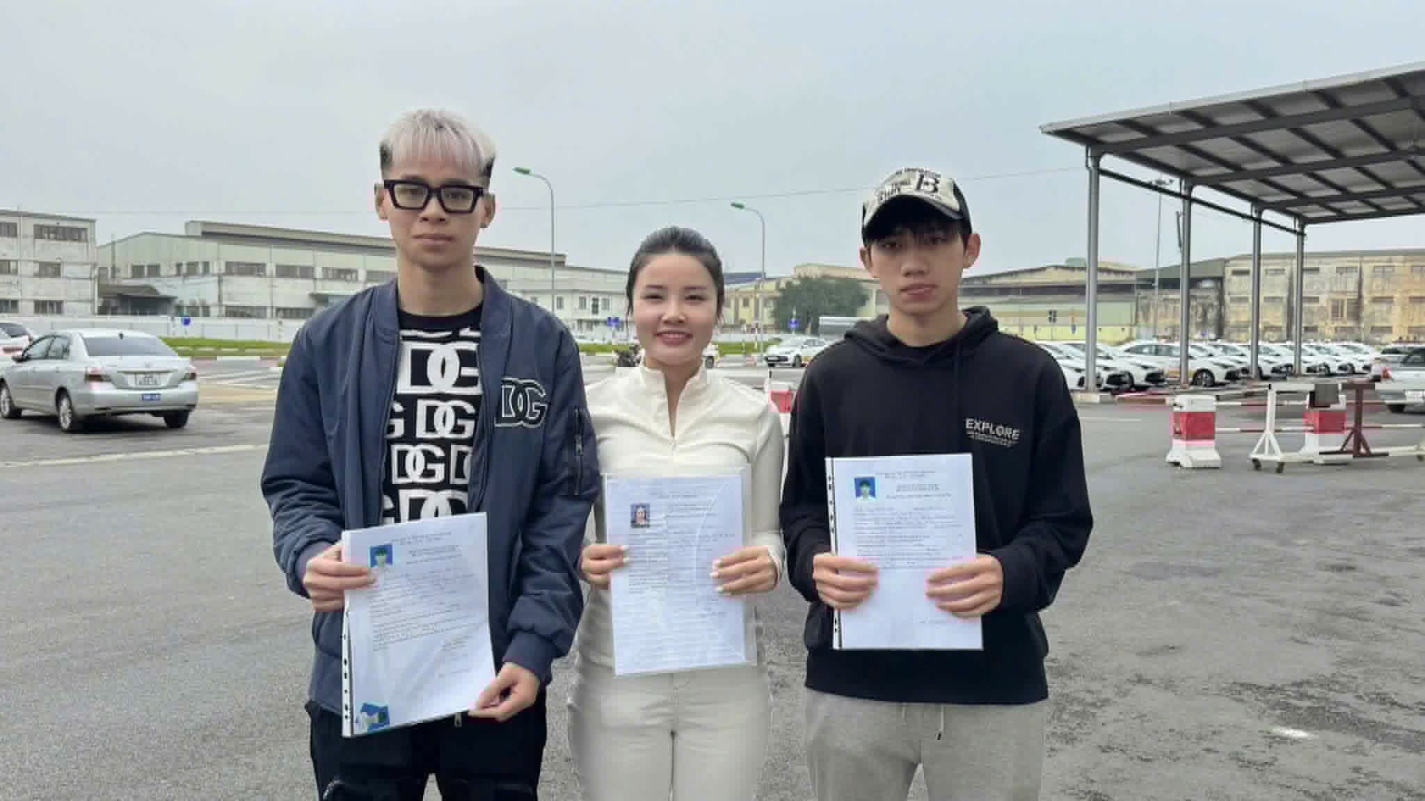 Cô Quỳnh cùng hai học viên cầm hồ sơ tại sân sát hạch