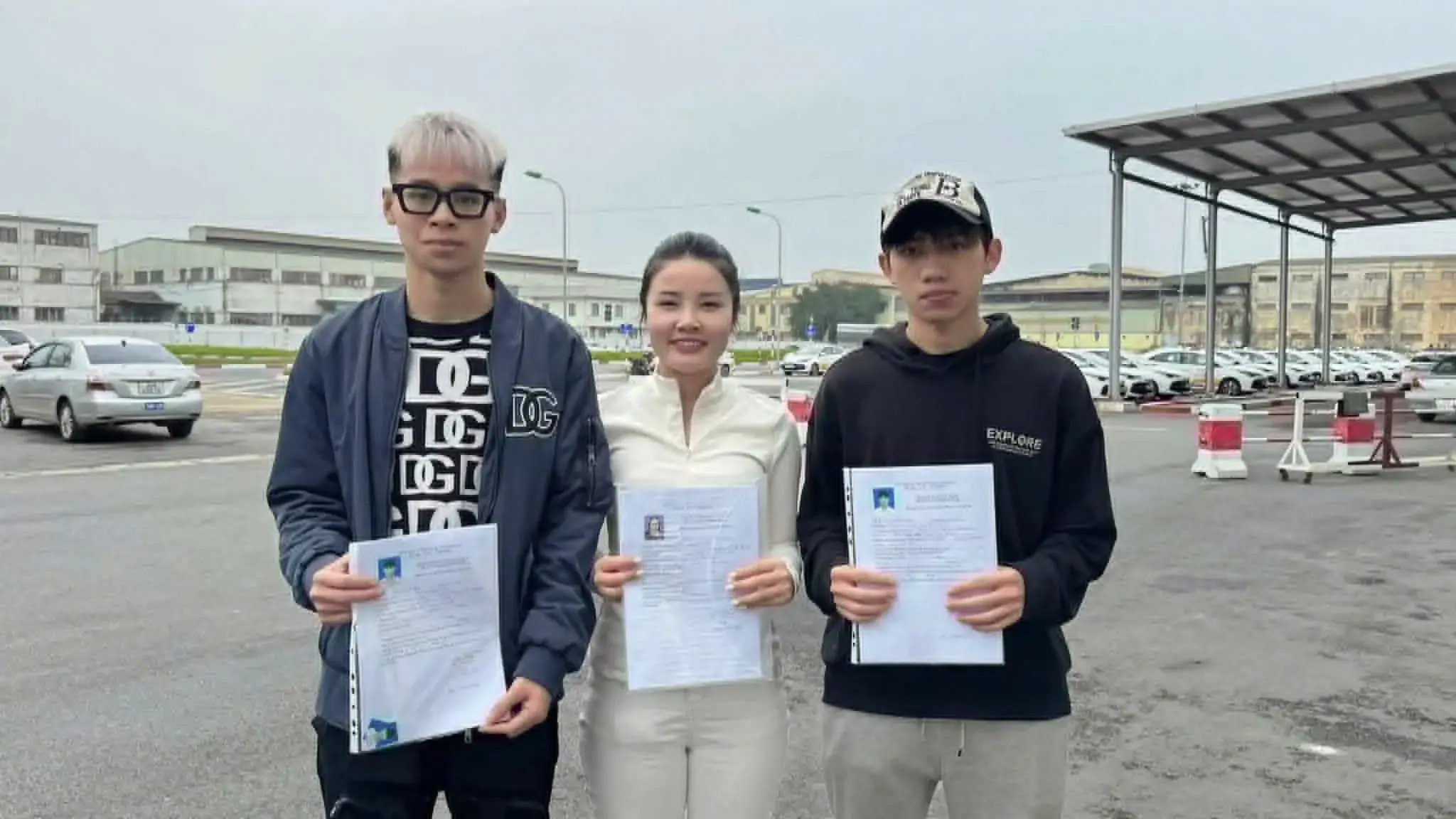 Cô Quỳnh cùng hai học viên cầm hồ sơ tại sân sát hạch